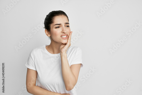 woman in white t-shirt toothache discomfort close-up photo