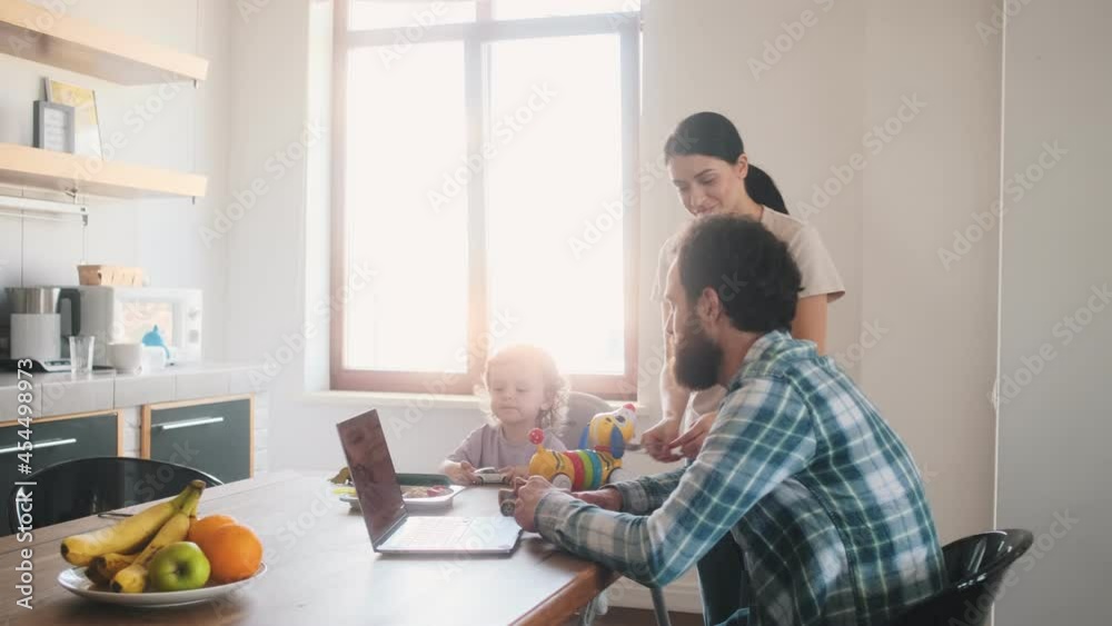 A positive family sitting and spending time in the kitchen at home A positive family sitting and spending time in the kitchen at home