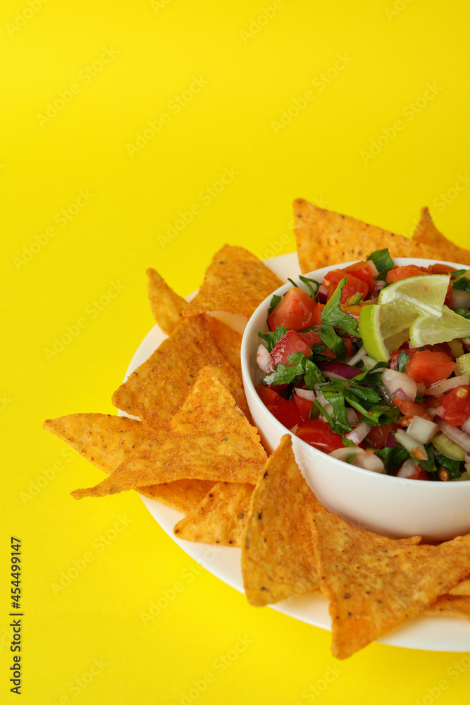 Pico de Gallo and chips on yellow background Pico de Gallo and chips on yellow background