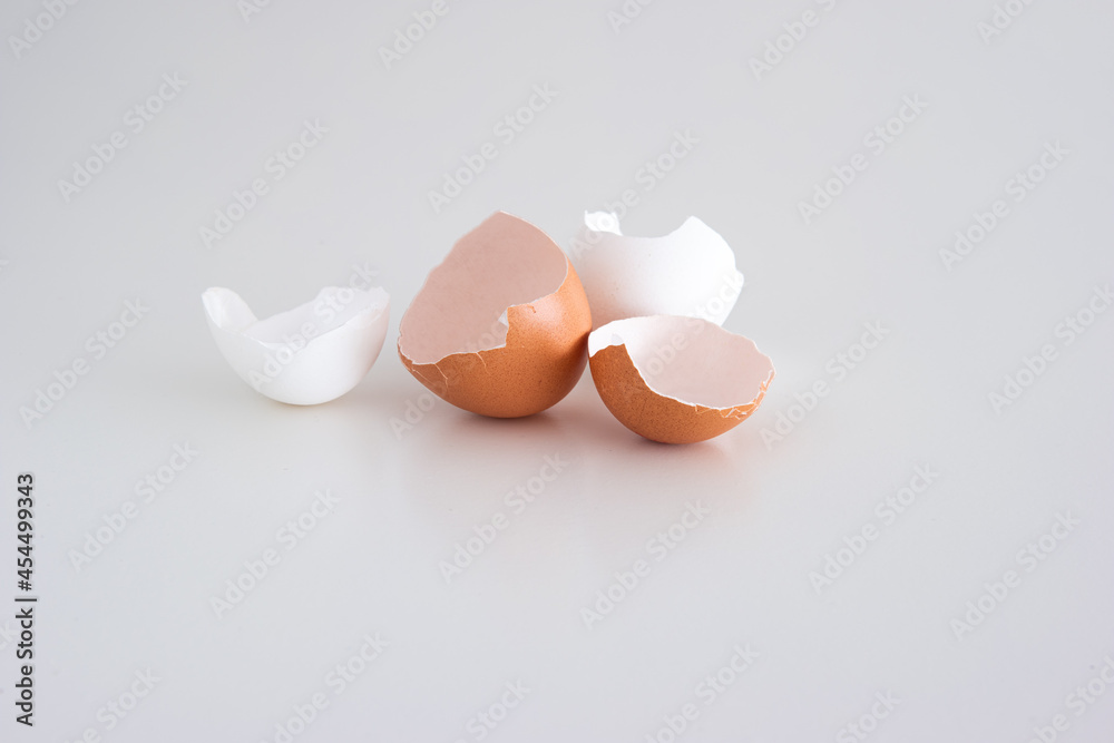 Cracked broken open chicken eggshells on white background. Close up shot, top view, no people Cracked broken open chicken eggshells on white background. Close up shot, top view, no people