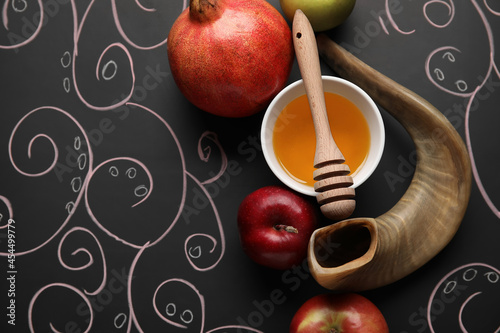 Honey with fruits and shofar on dark background. Rosh hashanah (Jewish New Year) celebration