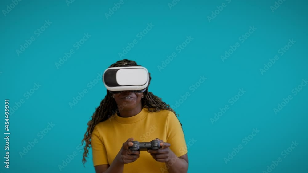 Carefree afro-american woman playing video game with joystick, using VR goggles Carefree afro-american woman playing video game with joystick, using VR goggles