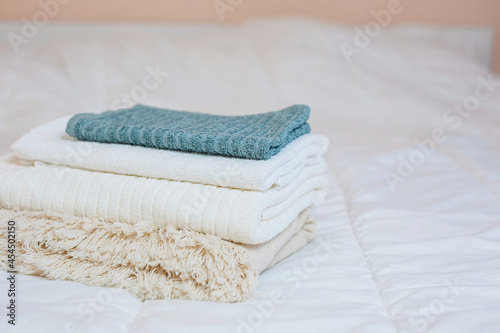 home textiles. A stack of towels lies on a white bed