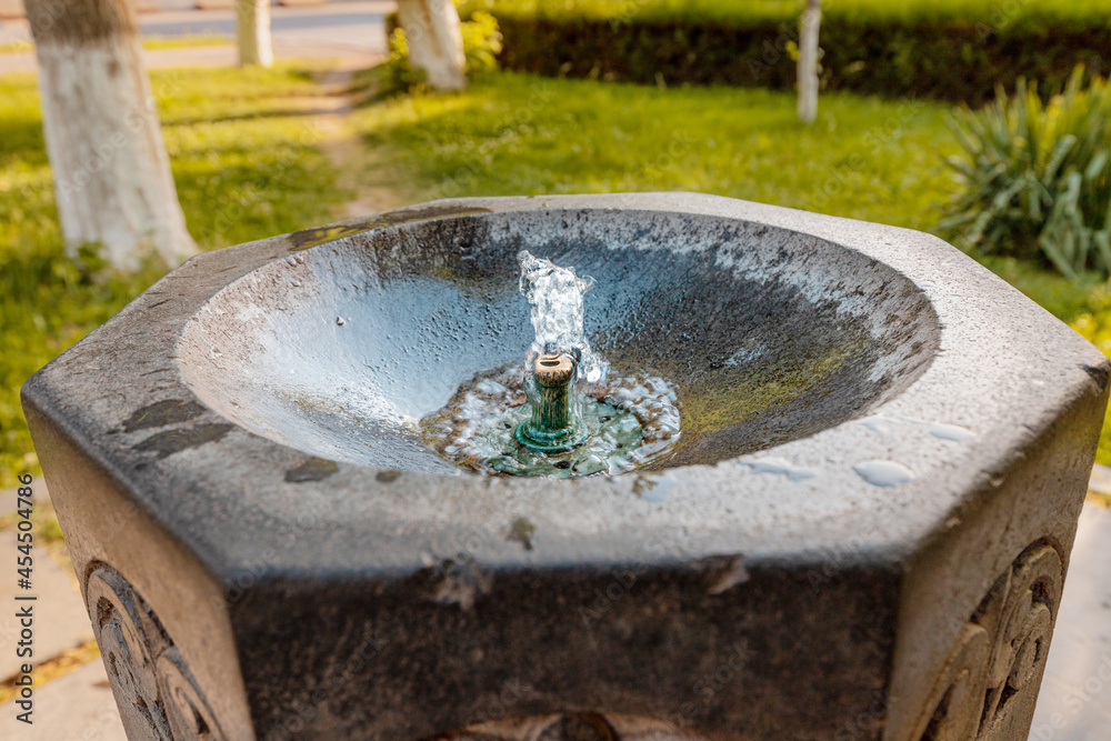 A drinking fountain on the street of the city. Clean water flows from the tap