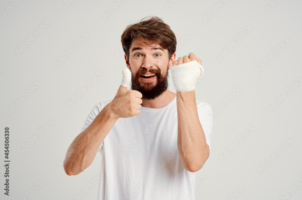 male patient in a white T-shirt with a bandaged hand posing hospital medicine male patient in a white T-shirt with a bandaged hand posing hospital medicine