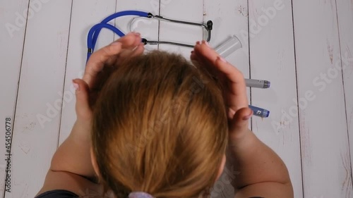 Close-up of a diabetic woman putting a glucose meter with very high blood sugar on the table and holding her head. Decompensated type 1 diabetes. photo