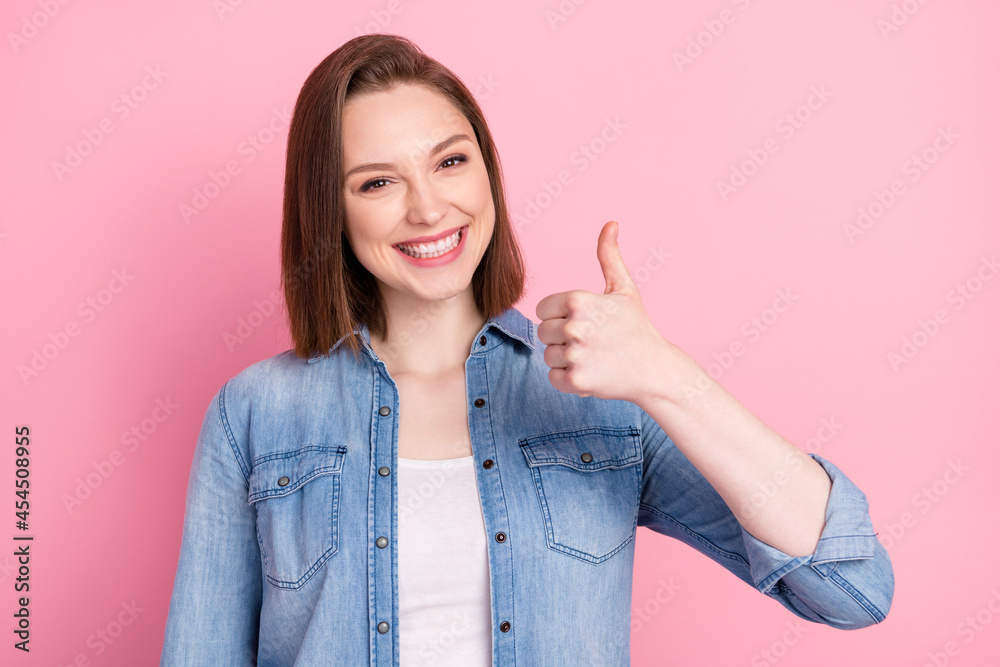 Photo portrait of girl smiling showing thumb-up like in casual outfit isolated pastel pink color background Photo portrait of girl smiling showing thumb-up like in casual outfit isolated pastel pink color background