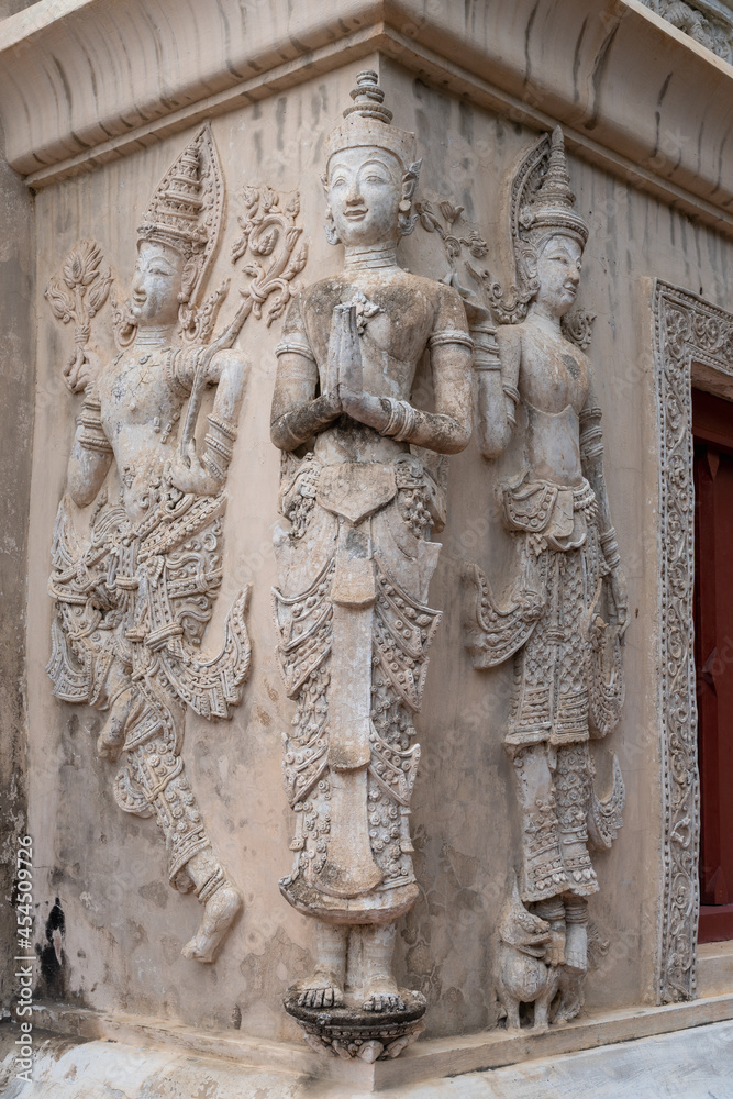 Beautiful ancient stucco carving life size figures on wall of hor trai library in Wat Phra Singh buddhist temple, famous landmark of Chiang Mai, Thailand