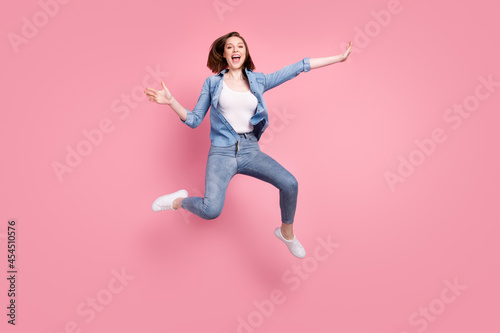 Full length body size photo girl laughing careless jumping high in stylish clothes isolated pastel pink color background