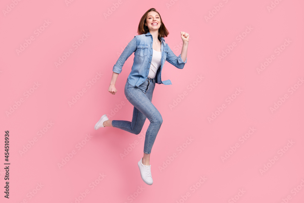 Full length body size photo girl jumping running fast smiling isolated pastel pink color background