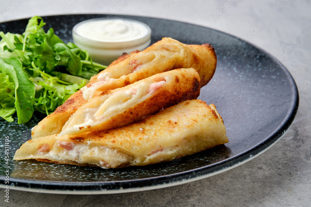 Closeup view of thin crepe stuffed with melted cheese and ham Closeup view of thin crepe stuffed with melted cheese and ham
