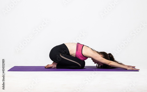 Sporty young woman doing yoga practice isolated on white background. Concept of healthy life and natural balance between body and mental development.