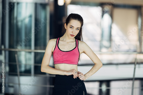 Beautiful young woman standing training at gym