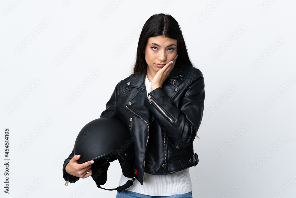 Young woman holding a motorcycle helmet over isolated white background unhappy and frustrated Young woman holding a motorcycle helmet over isolated white background unhappy and frustrated