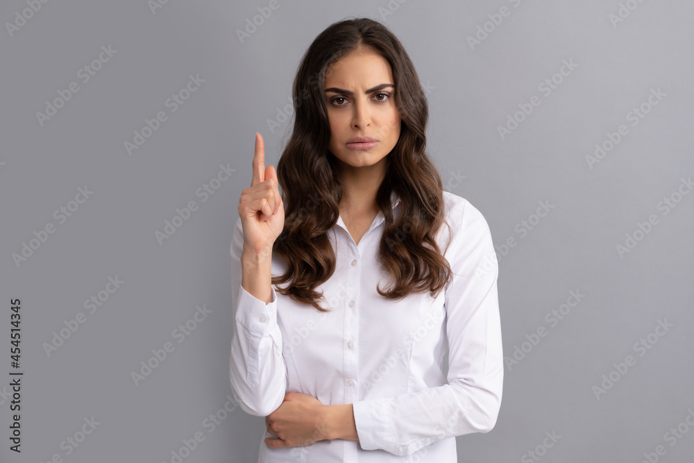 Frown woman executive manager keep finger pointing up grey background, idea Frown woman executive manager keep finger pointing up grey background, idea