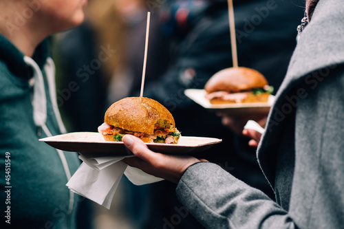 hand holding plates with fresh burger photo