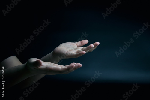 Symbol by hand. supplication and faith, intercession, encouragement gesture of male hands on black background with copy space photo