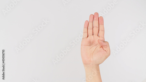  Signal for Help.Palm to camera and tuck thumb hand sign on white background. © nisara