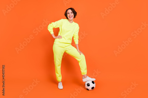 Fototapeta Naklejka Na Ścianę i Meble -  Full length body size view of attractive cheerful girl playing soccer euro 2021 having fun isolated over bright orange color background