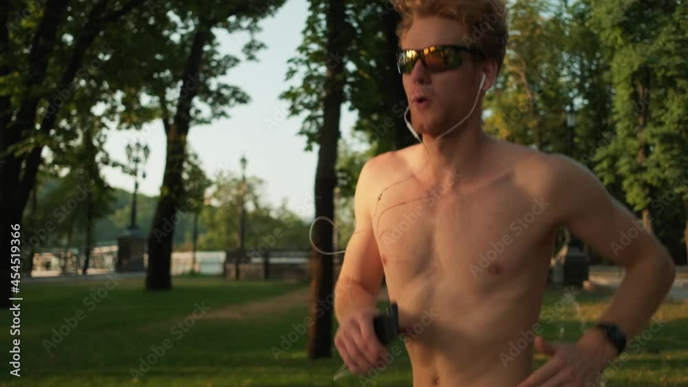 A half-naked sportsman running in the park at summer outside A half-naked sportsman running in the park at summer outside