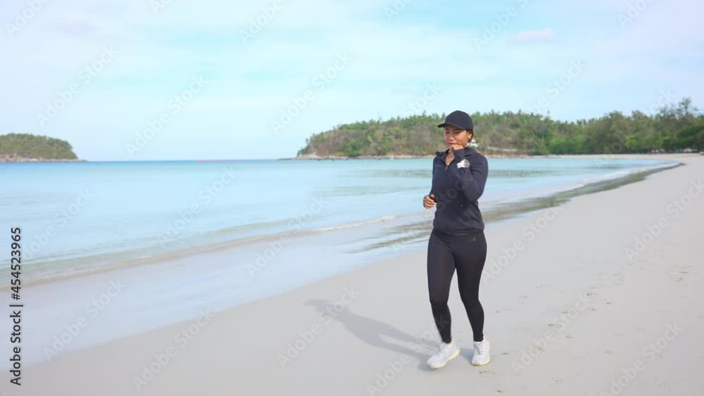 4K Confidence Asian woman in sportswear do sport training jogging on tropical beach in summer morning. Healthy female athlete workout fitness running on the beach. Outdoor activity lifestyle concept. 4K Confidence Asian woman in sportswear do sport training jogging on tropical beach in summer morning. Healthy female athlete workout fitness running on the beach. Outdoor activity lifestyle concept.