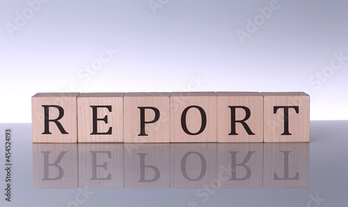 REPORT concept, wooden word block on the grey background