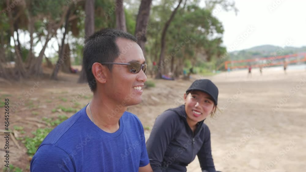 4K Happy confidence Asian family man and woman enjoy outdoor lifestyle activity beach running at tropical beach in summer vacation. Healthy couple in sportswear jogging together in summer sunny day. 4K Happy confidence Asian family man and woman enjoy outdoor lifestyle activity beach running at tropical beach in summer vacation. Healthy couple in sportswear jogging together in summer sunny day.
