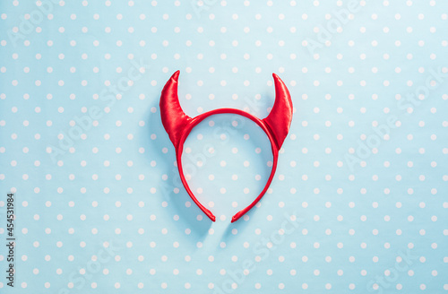 Fotografia Red devil horns on a headband hoop. Halloween texture background