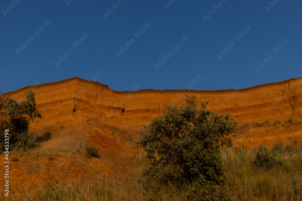 Geology. Desert landscape. Panorama view of the sandstone formation, the rocky cliffs, sand. Background or texture of sandy cliff on the coast, orange limestone Geology. Desert landscape. Panorama view of the sandstone formation, the rocky cliffs, sand. Background or texture of sandy cliff on the coast, orange limestone