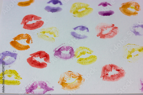 Set of multicolored female lip prints on white paper background top view. Kisses flatly. Lipstick prints, marks. Femininity, flirt, love concept. World Kissing Day. Valentine's Day. Lovely backdrop.