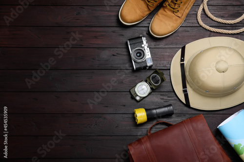 Flat lay composition with different safari accessories on wooden background, space for text