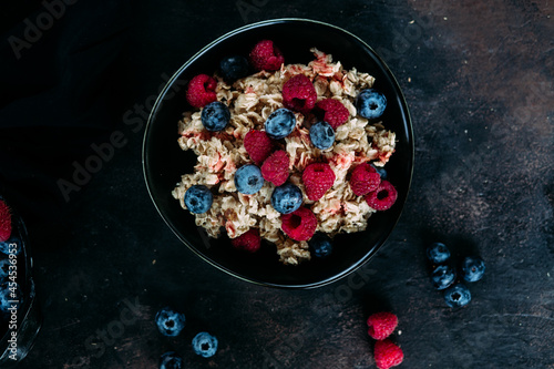 Oatmeal with raspberries and blueberries in a black plate