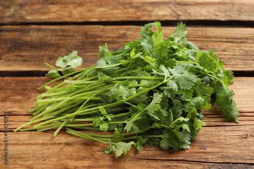Bunch of fresh aromatic cilantro on wooden table