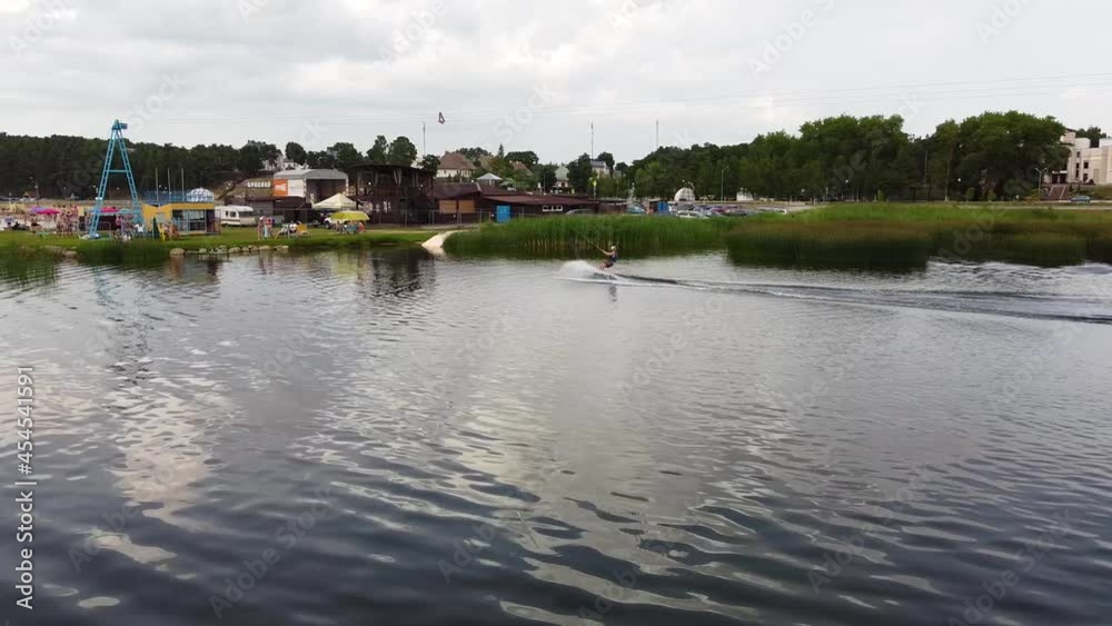 Athlete training wakeboarding on the river in a summer park