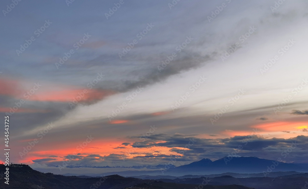 Tramonto arancio luminoso sopra le colline e le montagne dell’Appennino  