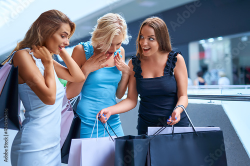 Three stylish woman holding shopping bags after shopping. Sale, consumerism, Black Friday