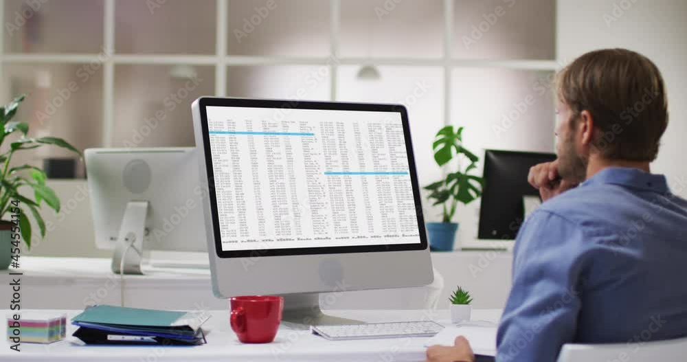Caucasian man sitting at desk coding data on laptop Caucasian man sitting at desk coding data on laptop
