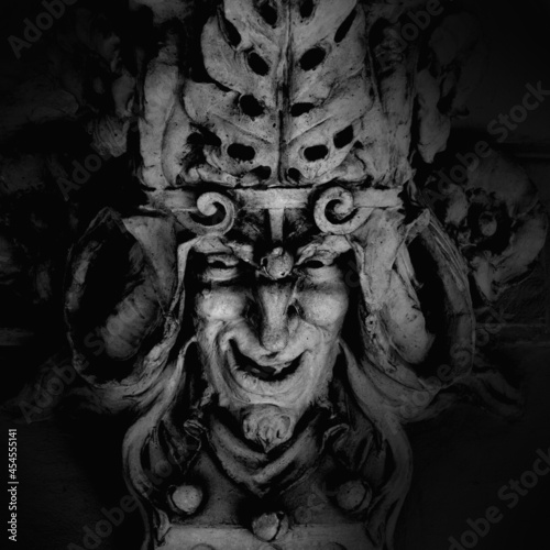 Monster face of Greek antique god daimon of eager rivalry, envy, jealousy, and zeal Zelus (Zelos). Fragment of an ancient stone statue. photo