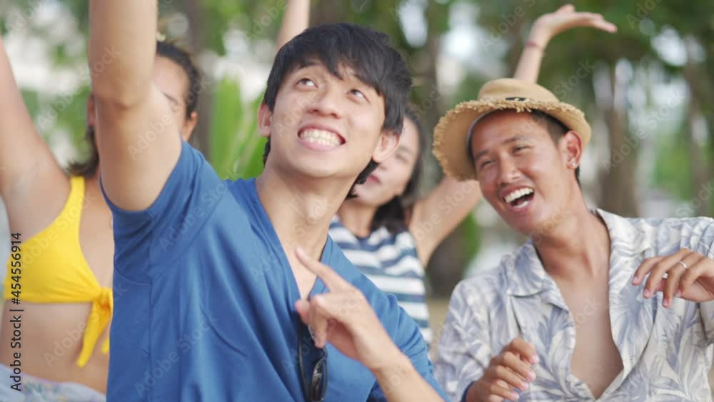 Asian man and woman friends sit on the beach enjoy picnic and use smartphone selfie or video call together on summer vacation. Male and female friendship having fun summer outdoor lifestyle activity. Asian man and woman friends sit on the beach enjoy picnic and use smartphone selfie or video call together on summer vacation. Male and female friendship having fun summer outdoor lifestyle activity.