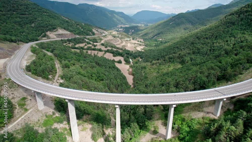 A bridge, a modern viaduct in the mountains with an asphalt road with ...