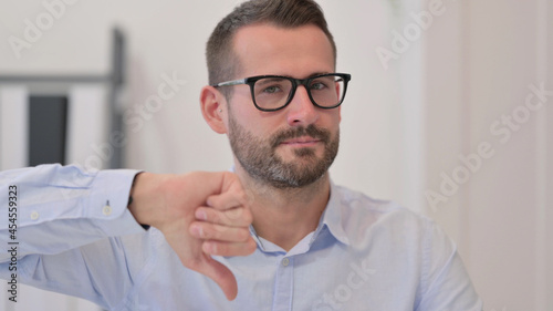 Fototapeta Naklejka Na Ścianę i Meble -  Portrait of Middle Aged Man showing Thumbs Down Sign 