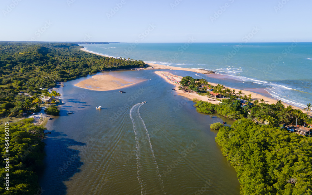 Vista aérea da vila de Caraíva em Porto Seguro, no sul da Bahia. Paraíso tropical com barcos e guarda-chuvas no pôr do sol tropical do Brasil.