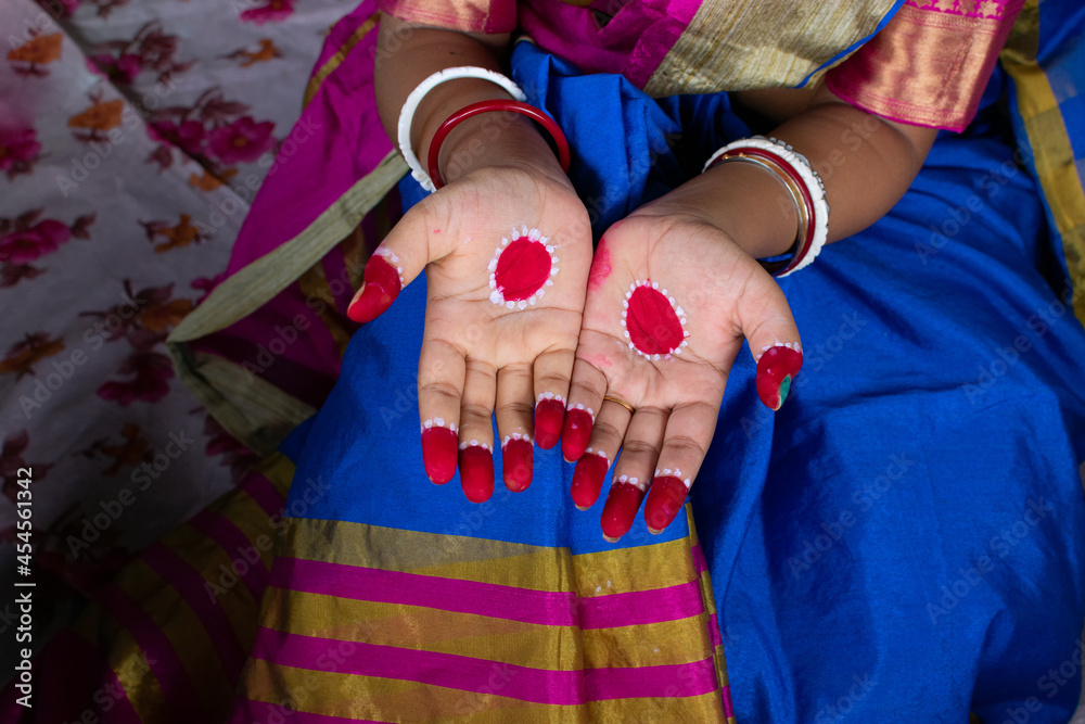 Indian woman getting ready with mehndi, before going out during the festival celebration. Selective focus on hands.