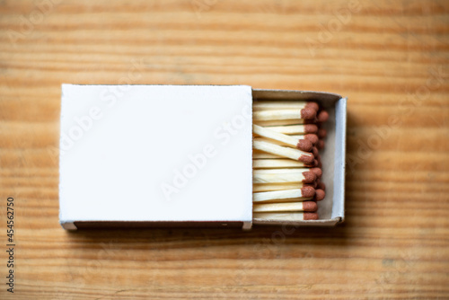 Cardboard box with matchsticks on wooden background, blank space top view. Space for design,flat lay copy space.