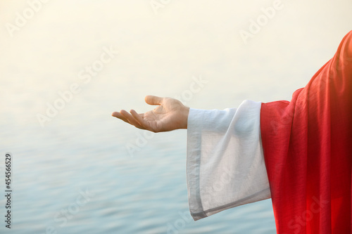 Photo Jesus Christ reaching out his hand near water outdoors, closeup