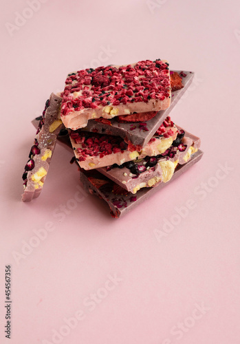 Fototapeta Naklejka Na Ścianę i Meble -  Slices of chokolate bars with nuts and berries with space for text