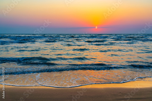 Colorful sunrise by the ocean shore