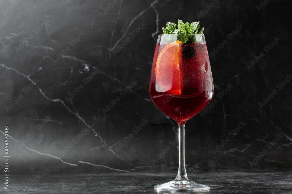 Closeup glass of red wine fresh sangria at bright bar counter background.