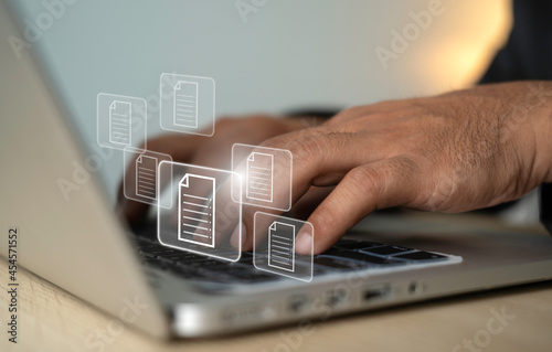 Hand press on keyboard with document icons and typing to laptop computer. Managing digital files and sending digital files. technology and business concept.