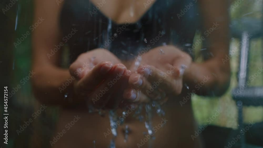 woman in shower catching water in hands enjoying refreshing cleanse showering outdoors in nature woman in shower catching water in hands enjoying refreshing cleanse showering outdoors in nature